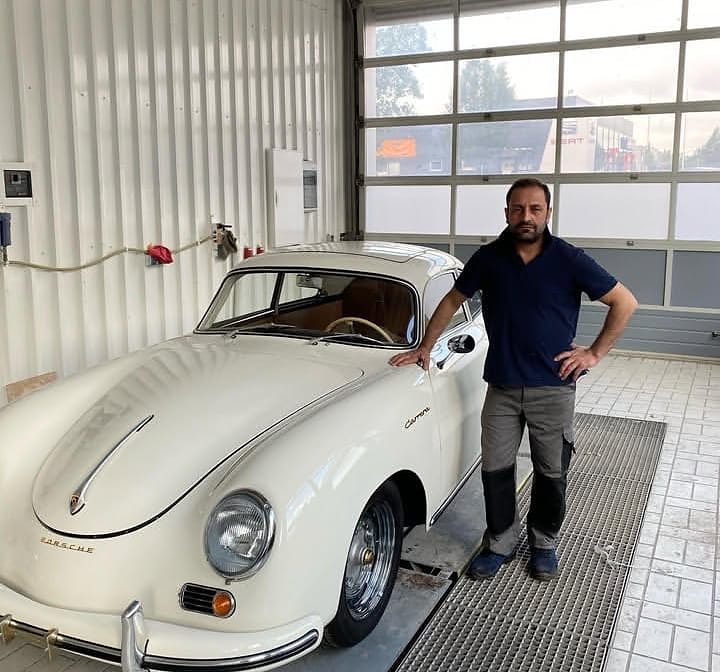 Chef neben einem Porsche 356